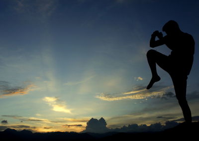 Silhouette couple standing against sky during sunset