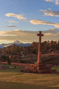 Cross on field against sky during sunset