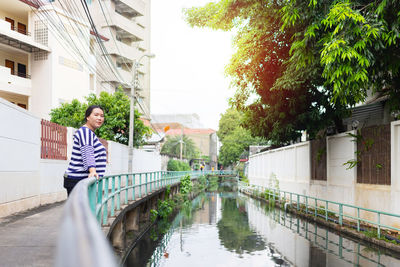 Reflection of man and woman looking at canal