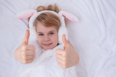 High angle view of cute baby girl lying on bed