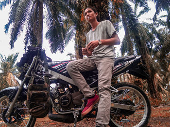 Full length of smiling woman riding motorcycle