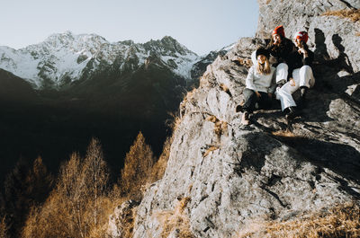 Low angle view of people on mountain against clear sky