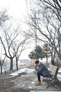 Low angle view of man sitting alone on street