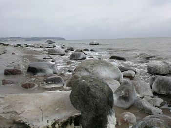 Rocks in sea against sky