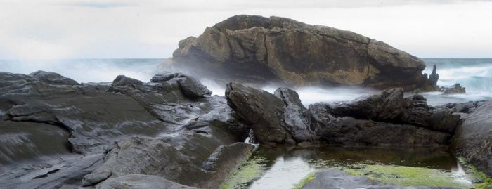 Rocks in sea against sky