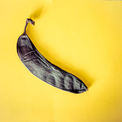 Close-up of a rotten banana on yellow background