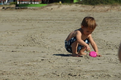 Boy playing on sand at beach