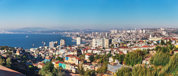 High angle view of townscape by sea against clear sky