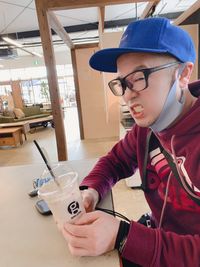 Young man looking away while sitting on table