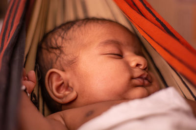 Close-up of cute baby boy sleeping on hammock