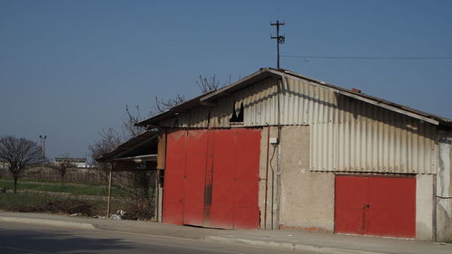 Road by building against clear blue sky