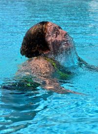 Woman swimming in pool on sunny day