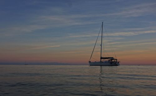 Boats in sea at sunset