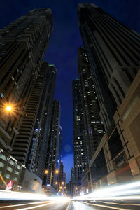 Low angle view of illuminated buildings against sky at night