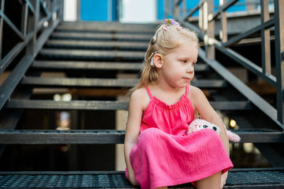 Portrait of young woman sitting on staircase