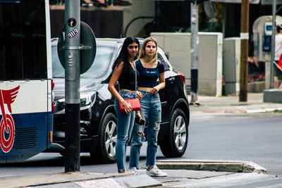 Portrait of woman with umbrella on street in city