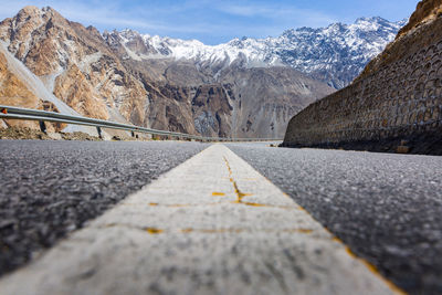 Surface level of empty road against snowcapped mountains