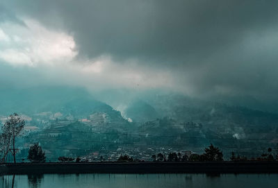 Scenic view of lake by mountains against sky