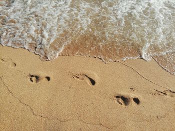 High angle view of footprints on sand at beach