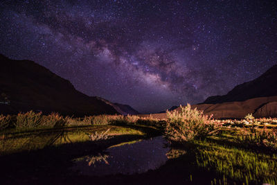 Scenic view of lake against mountains at night