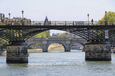 Bridge over river in city against sky