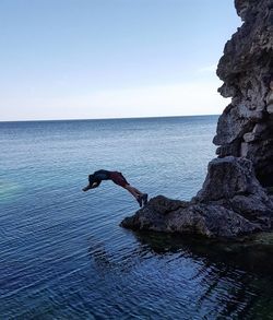 Woman on sea against clear sky