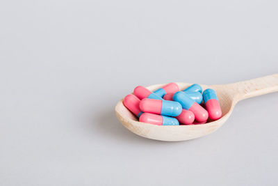 High angle view of pills in mortar against white background