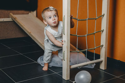 Active games for baby indoors activities. toddler girl play on home wooden indoor playsets. 