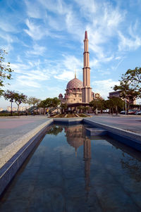Reflection of building in lake against sky