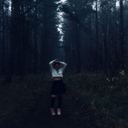 Full length of woman standing in forest