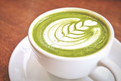 Close-up of green tea latte on table