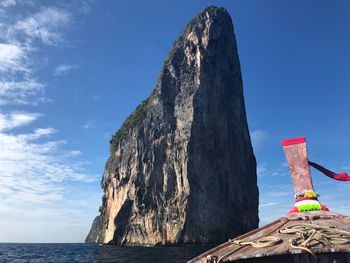 Rock formation by sea against blue sky