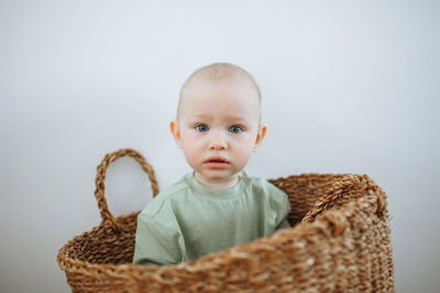 Close-up portrait of cute baby girl against white background