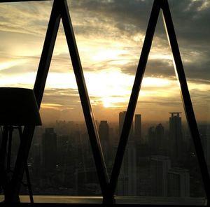 Skyscrapers against cloudy sky at sunset