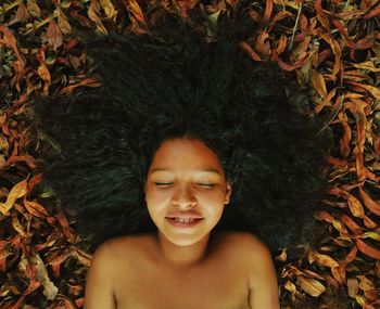 Shirtless woman lying on plants