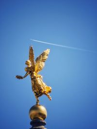 Low angle view of bird flying against clear blue sky