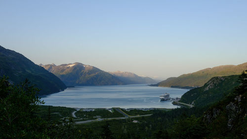 Scenic view of sea and mountains against clear sky