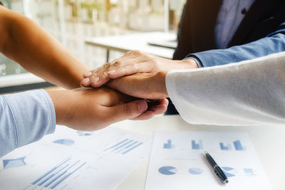 Close-up of hand holding hands on table