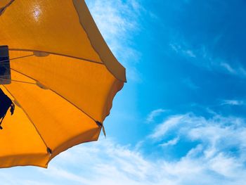 Low angle view of yellow parasol against sky