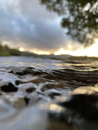 Surface level of beach against sky during sunset