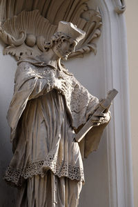 Saint john of nepomuk on the facade of parish church of the holy blood in graz, styria, austria