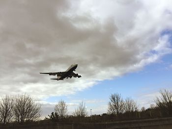 Low angle view of airplane flying against sky