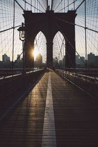 Brooklyn bridge against sky in city during sunset