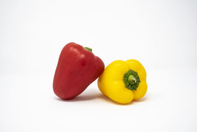 Close-up of yellow bell peppers against white background