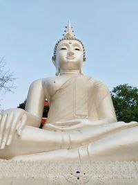 Low angle view of statue against building against clear sky