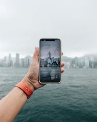 Hand holding mobile phone in water