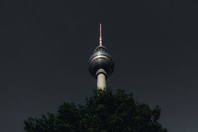 Low angle view of communications tower against sky at night