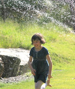 Full length of boy splashing water in park