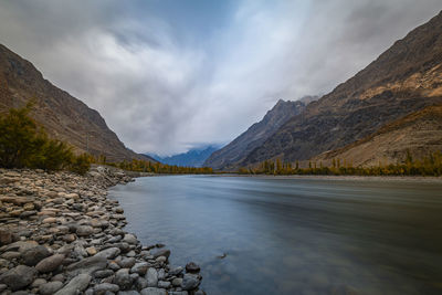 Scenic view of lake by mountains against sky