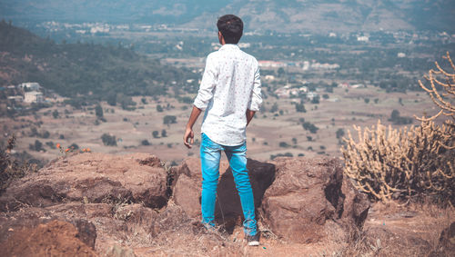 Rear view of man standing on rock